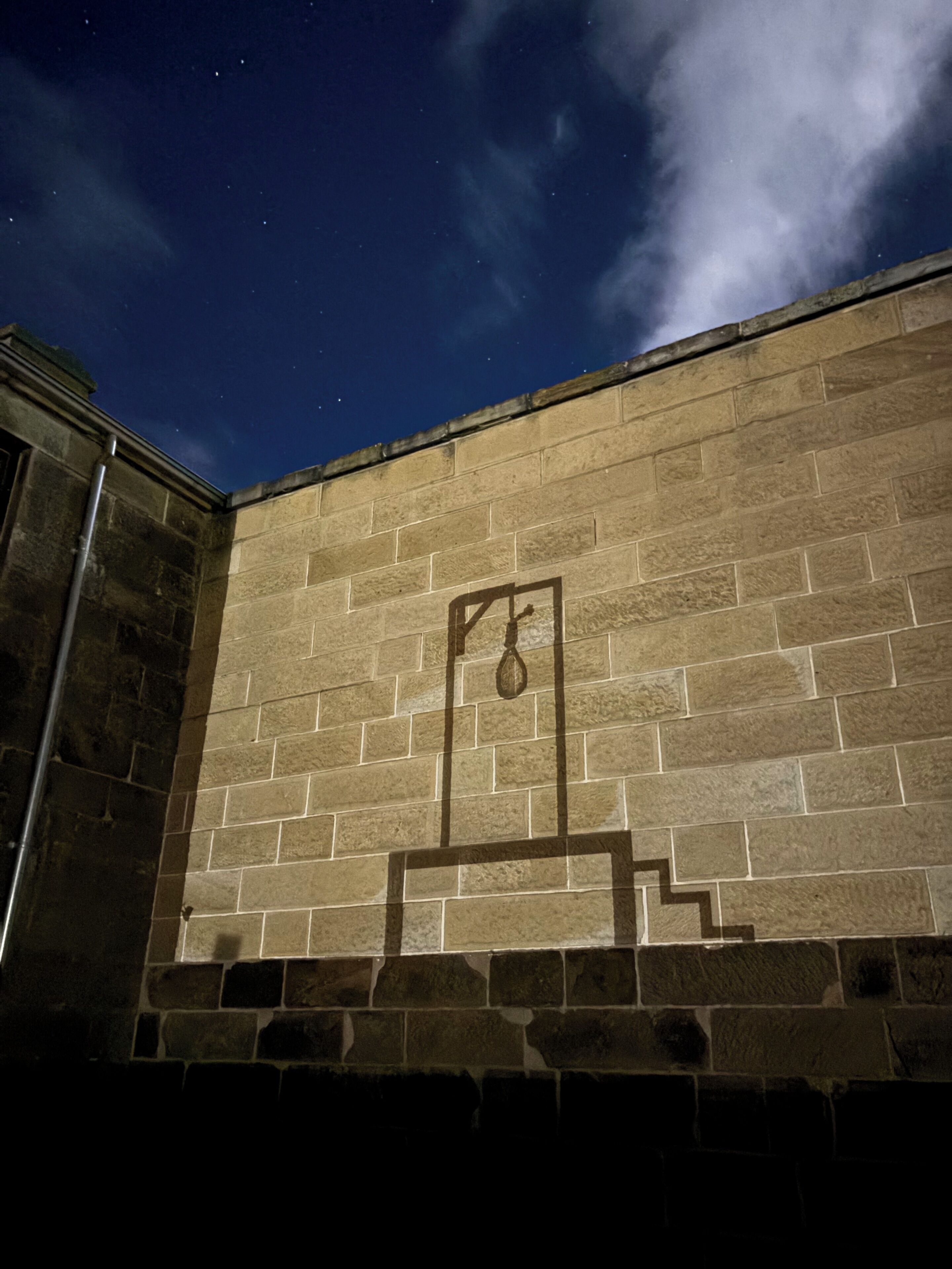 A brick wall with a geometric metal structure.