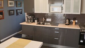 Una cocina moderna con armarios oscuros, un microondas y un lavabo.