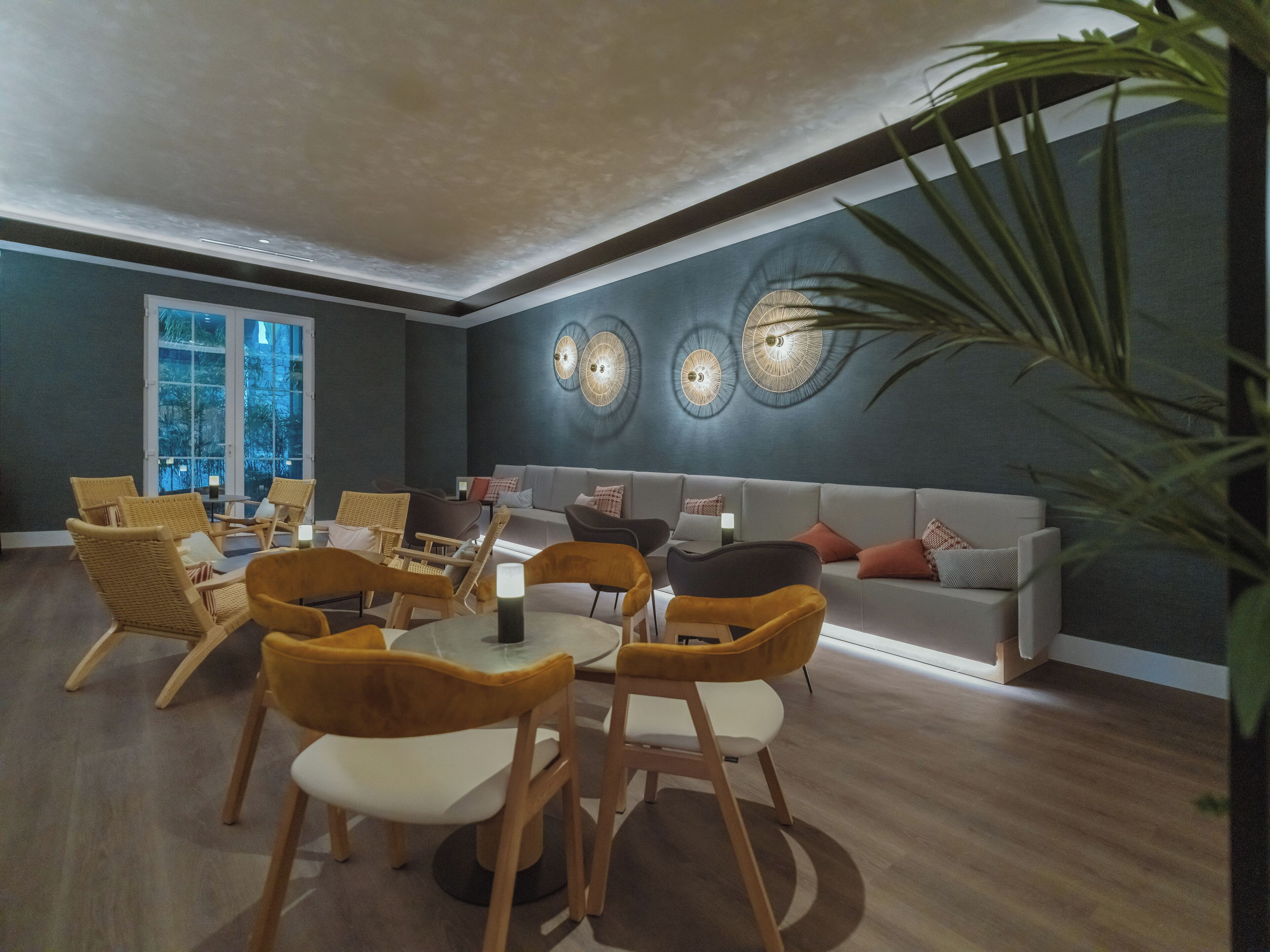 Una sala de estar moderna con sofá, sillones y una mesa de comedor.