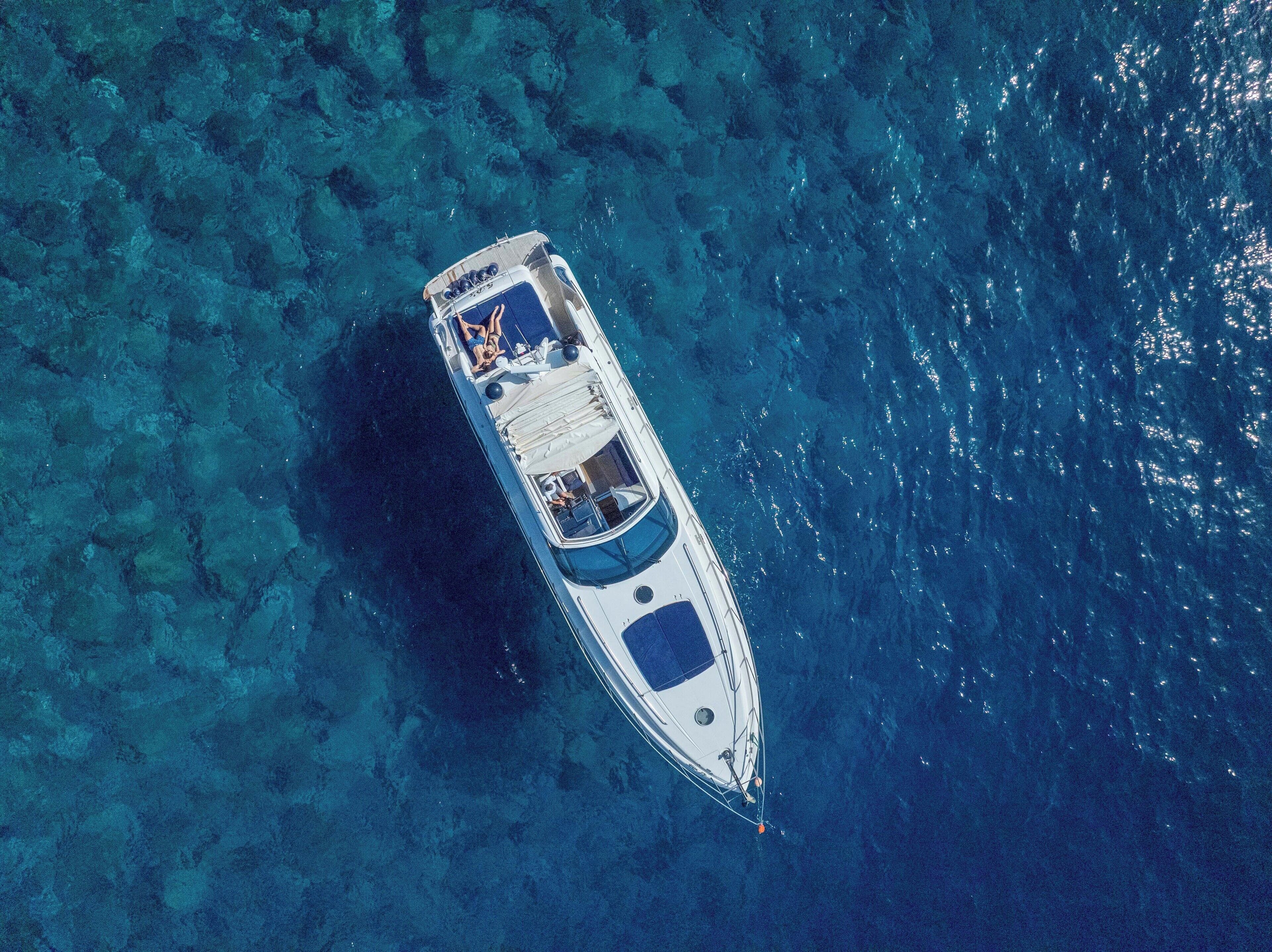 Vista aérea de un barco en aguas turquesas cristalinas.