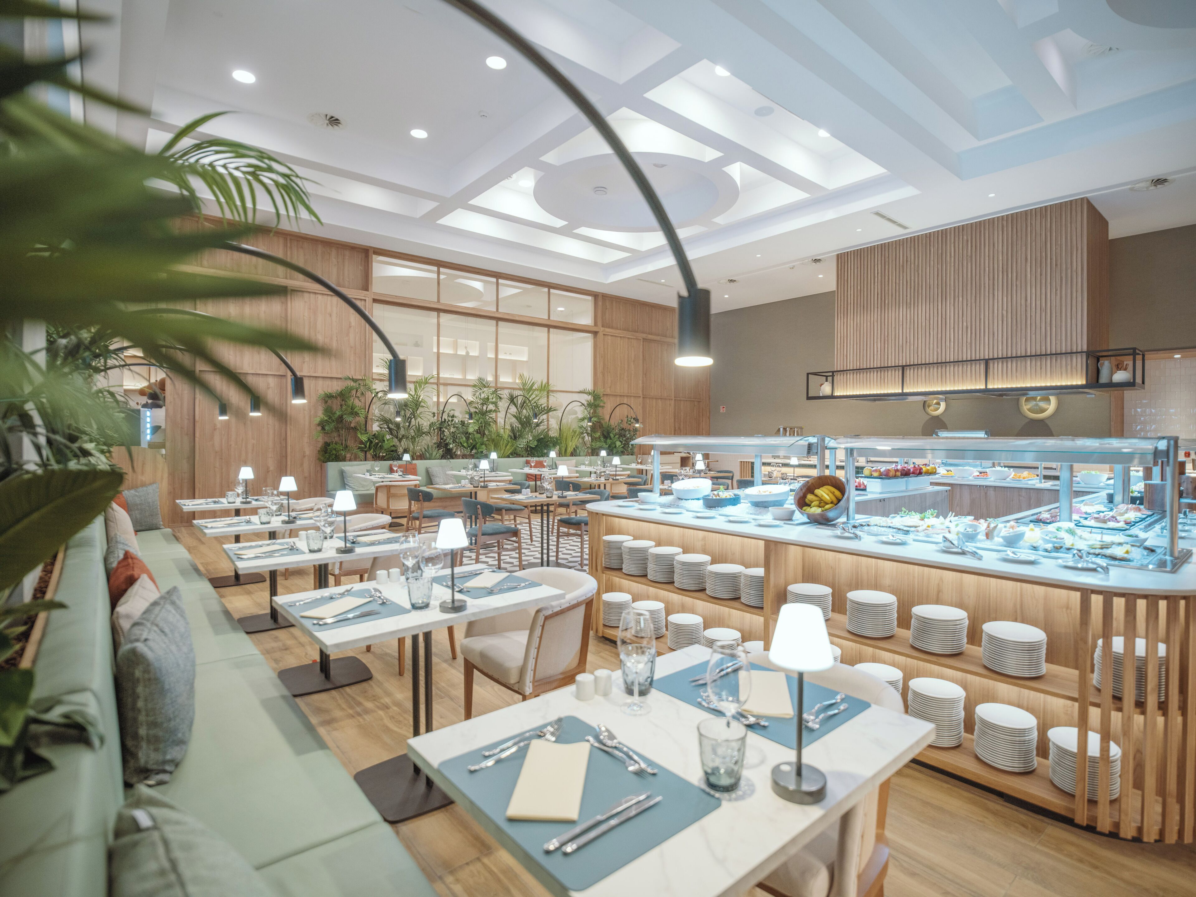A modern restaurant with multiple dining tables, a buffet area, and wooden paneling.