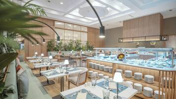 A modern restaurant with multiple dining tables, a buffet area, and wooden paneling.
