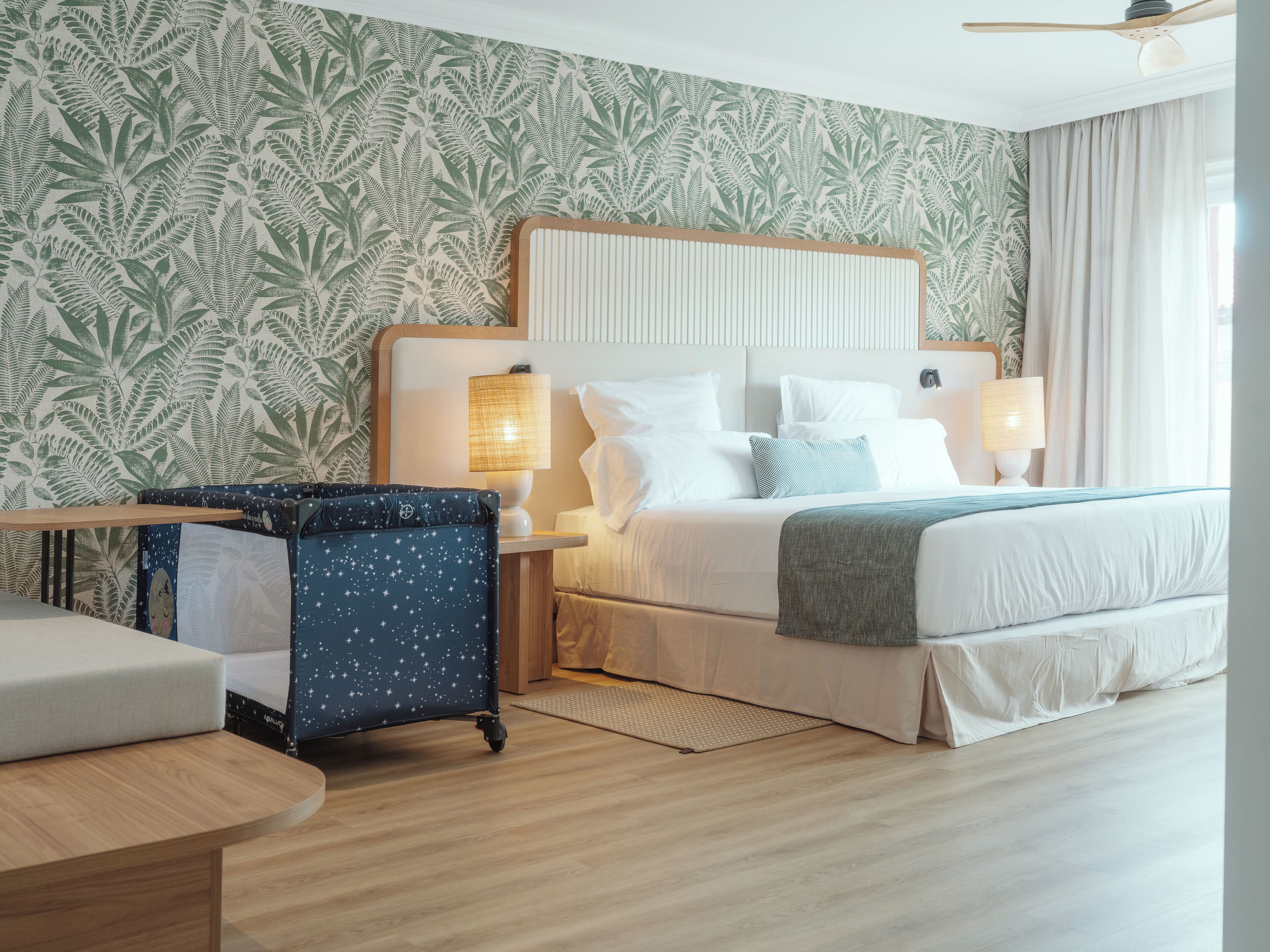 A hotel room with a bed, two bedside tables, a desk, and a chair.