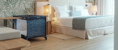 Una habitación de hotel con una cama, dos mesitas de noche, un escritorio y una silla.