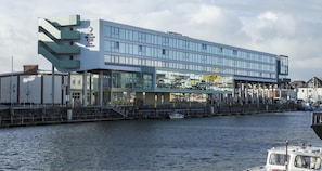 A modern hotel with a glass facade, located by a waterfront. - Best Western Plus Hotel Bremerhaven (Bremerhaven)
