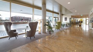 A spacious lobby with large windows, a polished floor, and modern seating. - Best Western Plus Hotel Bremerhaven (Bremerhaven)