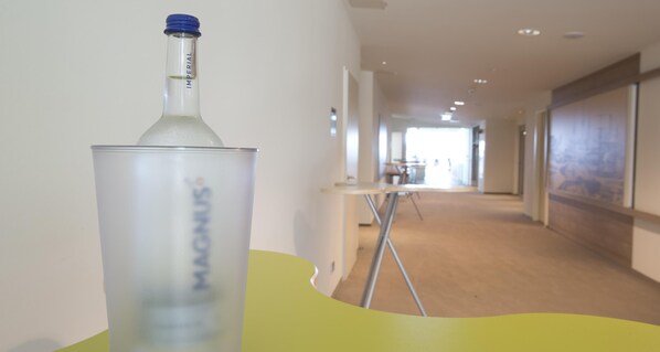 A hallway with a clear view of a bottle labeled 'MAGNUM' on a table. - Best Western Plus Hotel Bremerhaven (Bremerhaven)