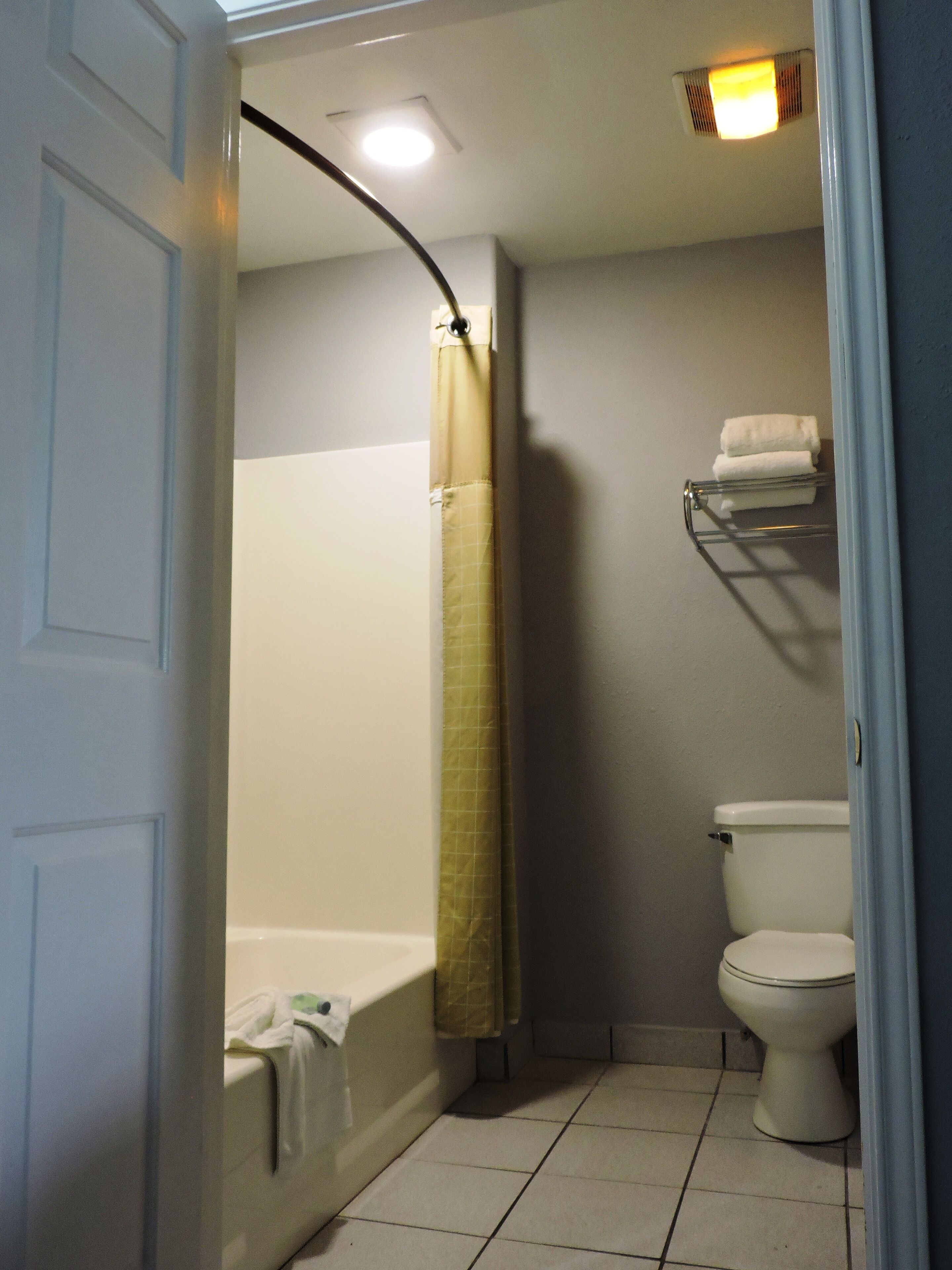Un baño con bañera, inodoro y perchero para toallas.