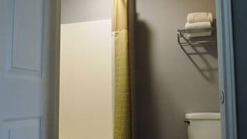 Un baño con bañera, inodoro y perchero para toallas.