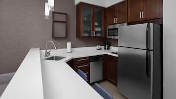 A modern kitchen with a stainless steel refrigerator, a dishwasher, and a microwave.