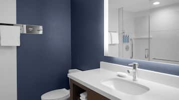 Un baño moderno con un lavabo blanco, un espejo y un inodoro.