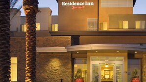A modern building with a "Residence Inn Marriott" sign, featuring a glass entrance, stone facade, and landscaped surroundings with palm trees. - Residence Inn Tustin Orange County (Tustin)