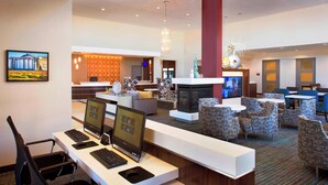 A hotel lobby with a reception desk, computers, seating area, and a fireplace. - Residence Inn Tustin Orange County (Tustin)