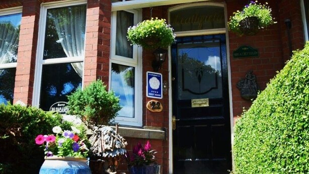 A red brick building with a black front door, a sign reading "HEATHFIELD," and a plaque indicating a "CERTIFIED GUEST HOUSE." - Heathfield B&B Guest House (Whitby)