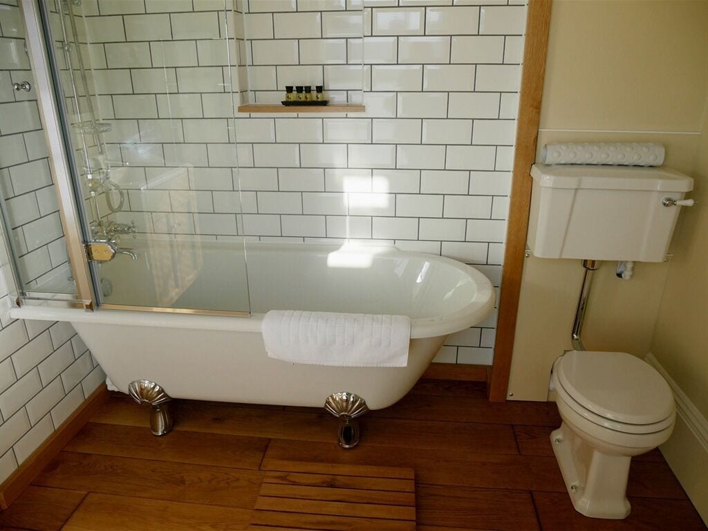 A bathroom with a freestanding bathtub, a glass shower enclosure, and a toilet.