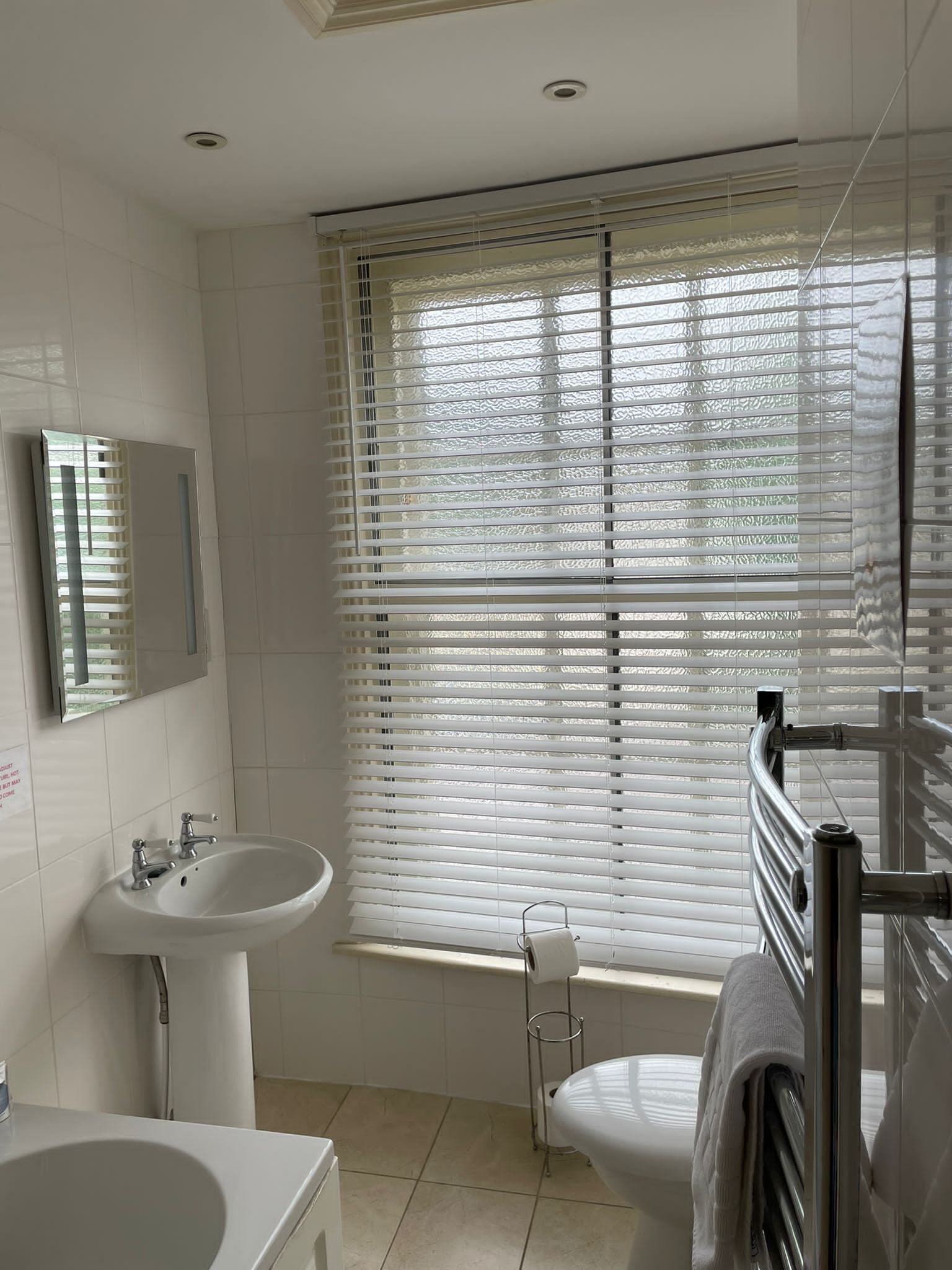 A modern bathroom with a sink, mirror, and toilet.