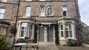 A stone building with a sign reading "Geminian" above the entrance. - Geminian Guest House (Harrogate)