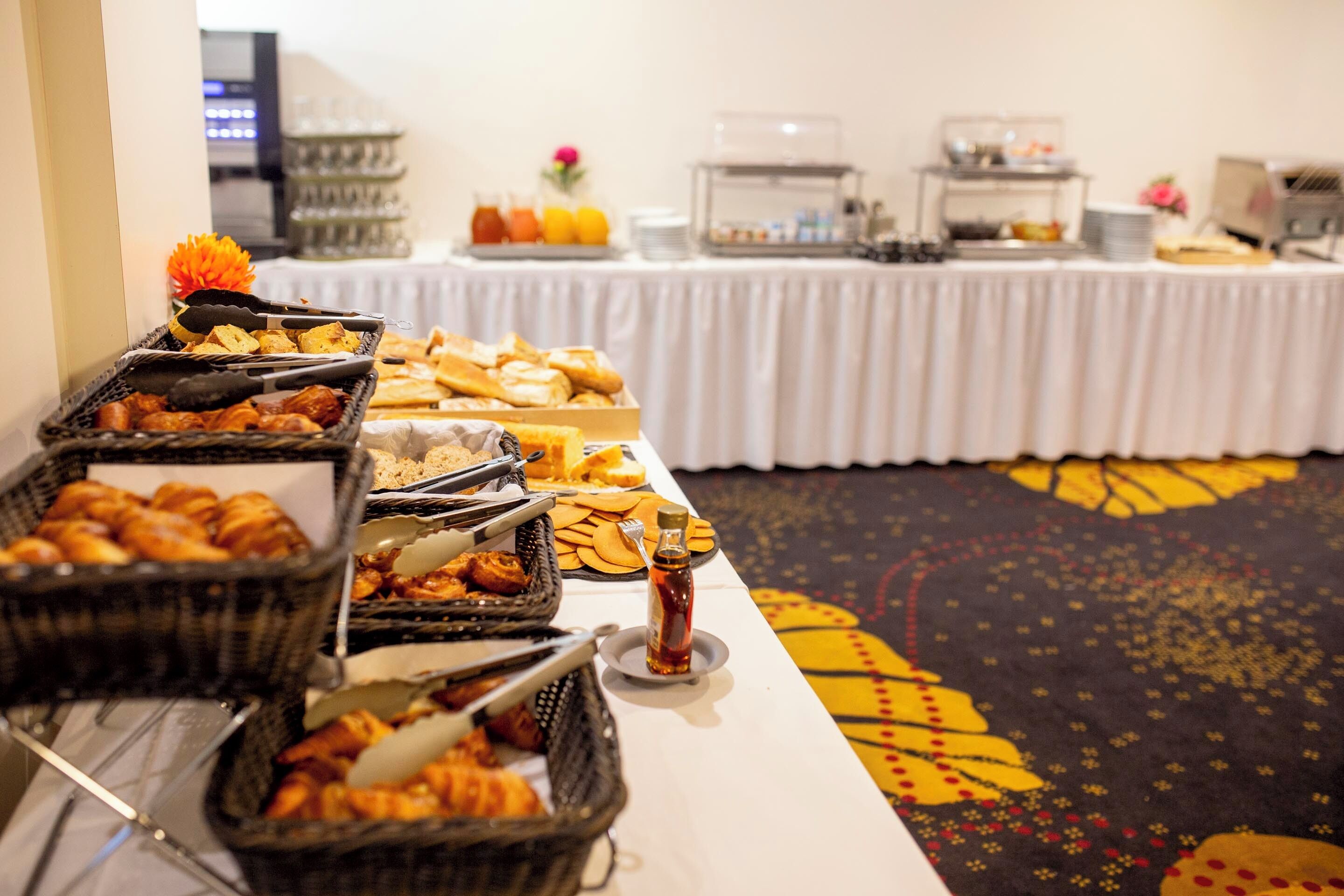 A buffet table with various food items and condiments.