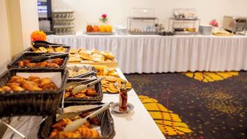 A buffet table with various food items and condiments.
