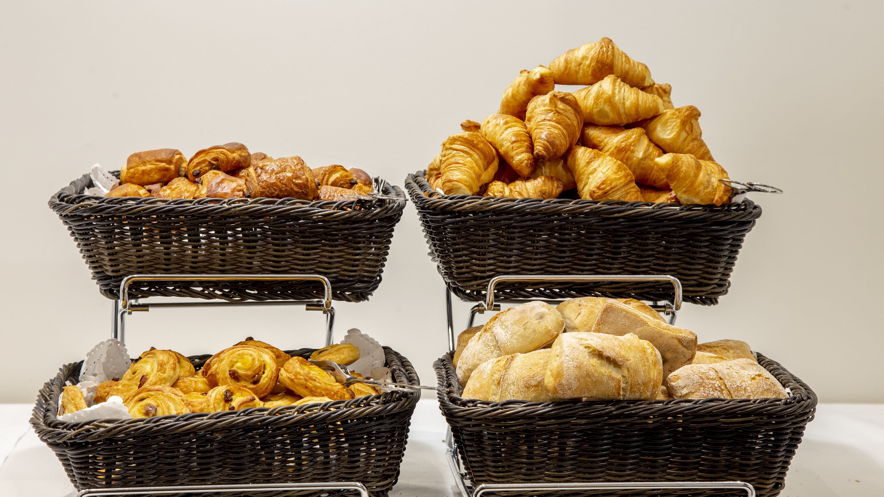 Four wicker baskets filled with various baked goods.