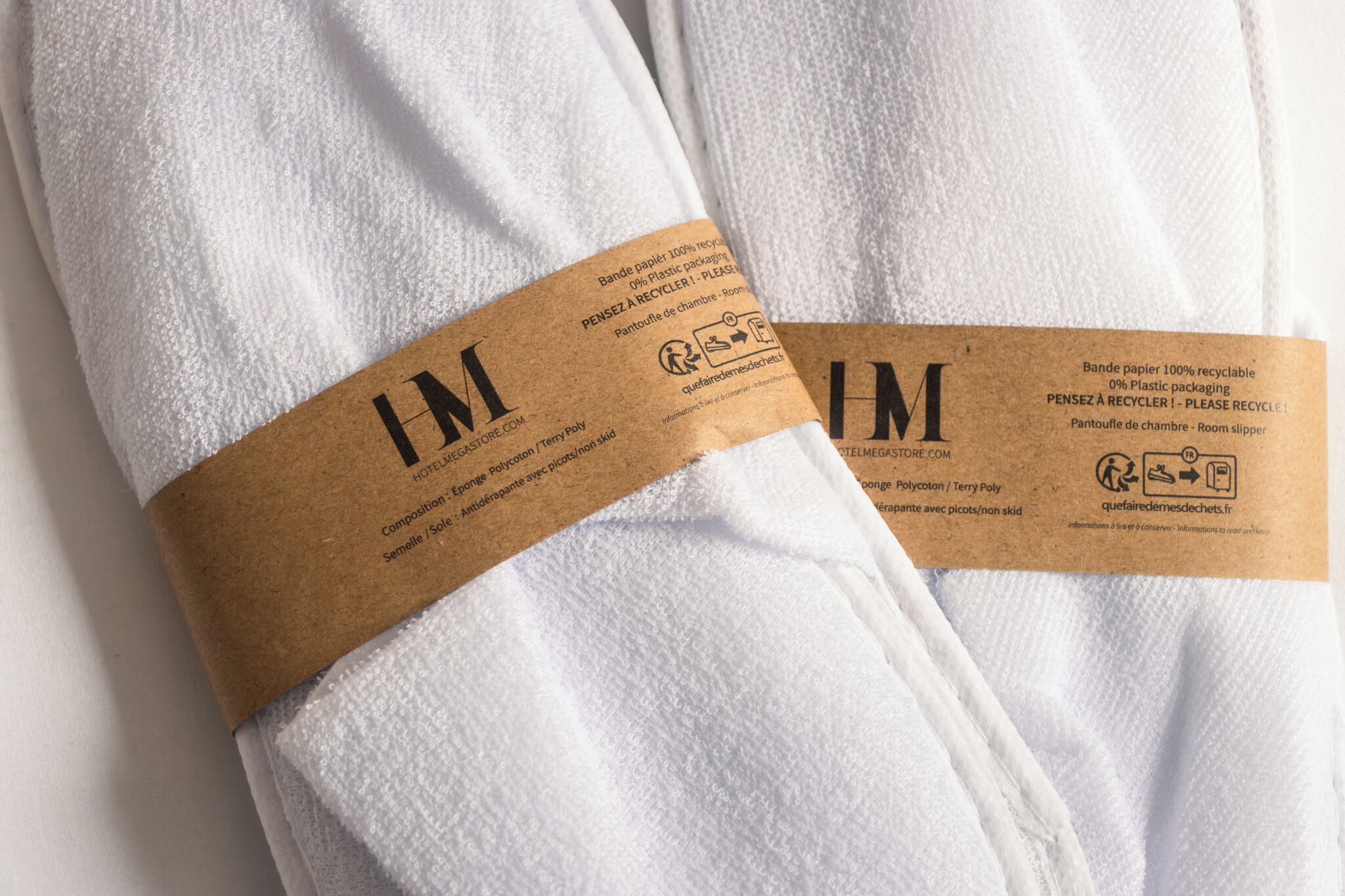 Two white towels with brown labels.