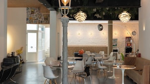 A modern interior with a central seating area, a staircase, and a wall with greenery. - Hotel Retro (Brussels)