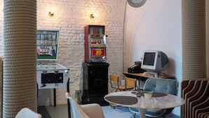 A retro-themed room with a jukebox, a vintage television, and a small table with chairs. - Hotel Retro (Brussels)