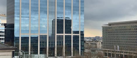Un moderno edificio de gran altura con ventanas de vidrio reflectante y una antena destacada en la parte superior.