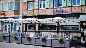 A restaurant with outdoor seating, a brick facade, and a sign reading "LA LIBERTE". - Hôtel-Restaurant L’Auberge (Spa)