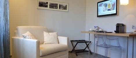A modern living room with a sofa, a small table, and a bar area with stools.