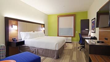 Ein Hotelzimmer mit Bett, Schreibtisch, Stuhl und einem großen Fenster.