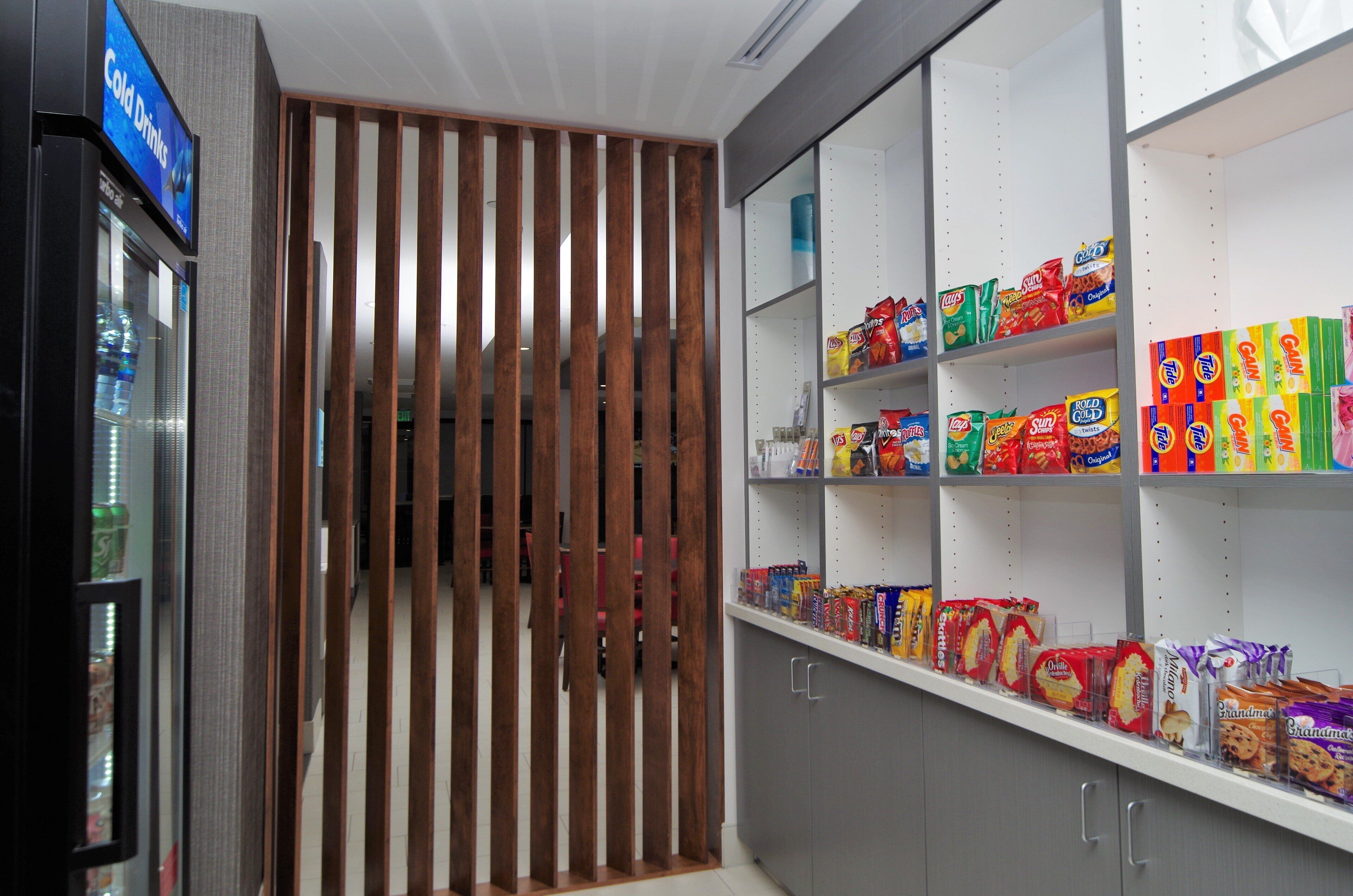 A snack aisle with various packaged snacks and a refrigerated section on the left.