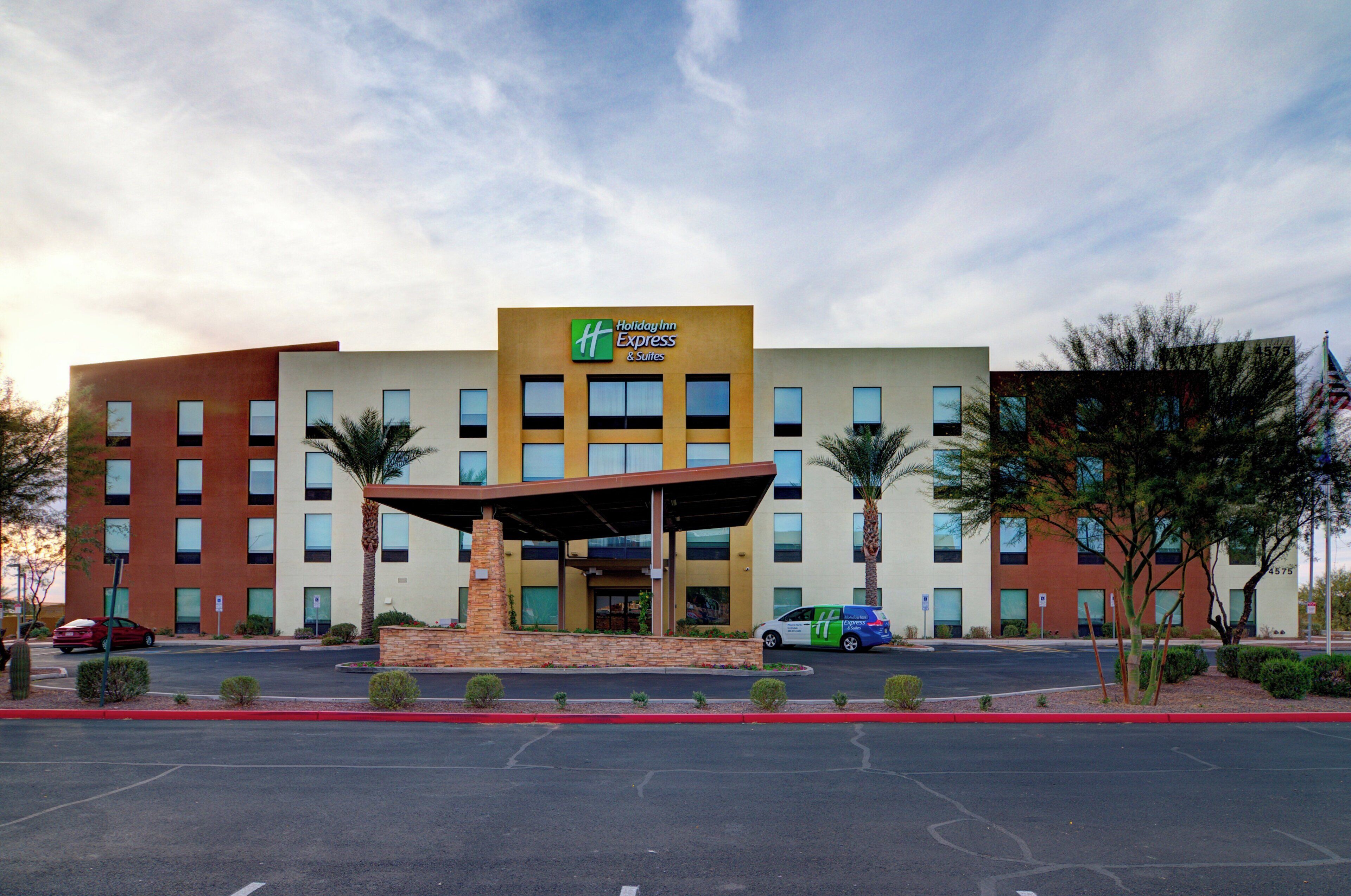 A Holiday Inn Express & Suites hotel with a covered entrance, multiple floors, and a parking lot.