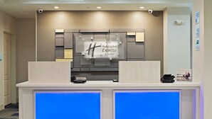 A Holiday Inn Express & Suites reception desk with a modern design, including a digital display and a sign above the desk. - Holiday Inn Express Hotel & Suites Phoenix North Scottsdale by IHG (Phoenix)