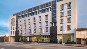 A modern hotel with a flat facade, multiple windows, and a visible entrance with a sign. - Hampton Inn by Hilton North Hollywood (North Hollywood)