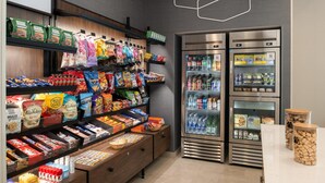 A snack and beverage section with shelves stocked with various snacks and a refrigerated display case. - Hampton Inn by Hilton North Hollywood (North Hollywood)