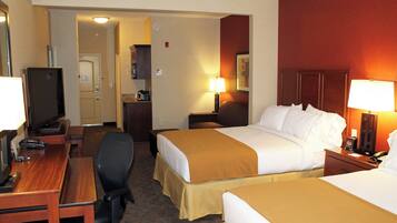 A hotel room with two beds, a desk, a television, and a telephone.