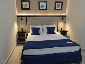 Habitación doble Deluxe | Minibar y ropa de cama 