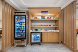A self-service shop area with refrigerated beverage dispensers and a small refrigerator, likely for snacks and drinks. - Holiday Inn Express Hotel & Suites Selinsgrove by IHG (Selinsgrove)