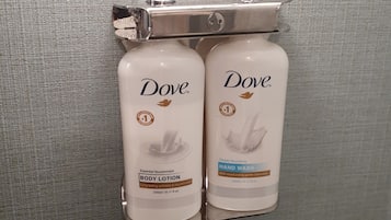 Dos dispensadores de loción corporal Dove fijados a una pared.