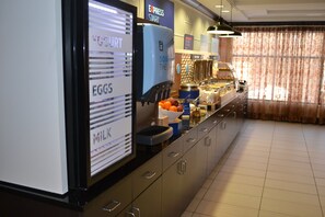 A breakfast buffet area with labeled food stations for eggs, milk, and yogurt. - Holiday Inn Express Hotel & Suites Selinsgrove by IHG (Selinsgrove)
