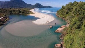 A coastal landscape with a sandy beach, clear waters, and lush greenery. - Itamambuca Eco Resort (Ubatuba)
