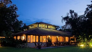 A two-story building with a tiled roof and large windows, surrounded by greenery. - Itamambuca Eco Resort (Ubatuba)
