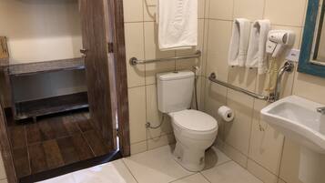 A bathroom with a toilet, a sink, a towel rack, and a shower.