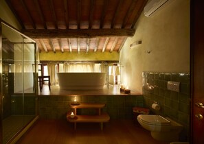 A bathroom with a bathtub, toilet, and a bench. - B&B Borgo Petrognano - Residenza d'epoca (Barberino Tavarnelle)