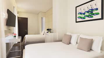 Habitación de hotel con una cama grande, un escritorio con silla, un televisor de pantalla plana y un cuadro en la pared.