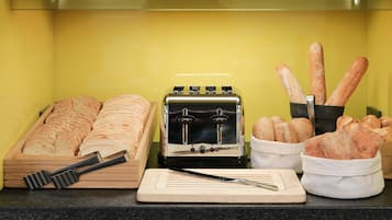 A kitchen counter with a toaster, bread, and bread baskets.