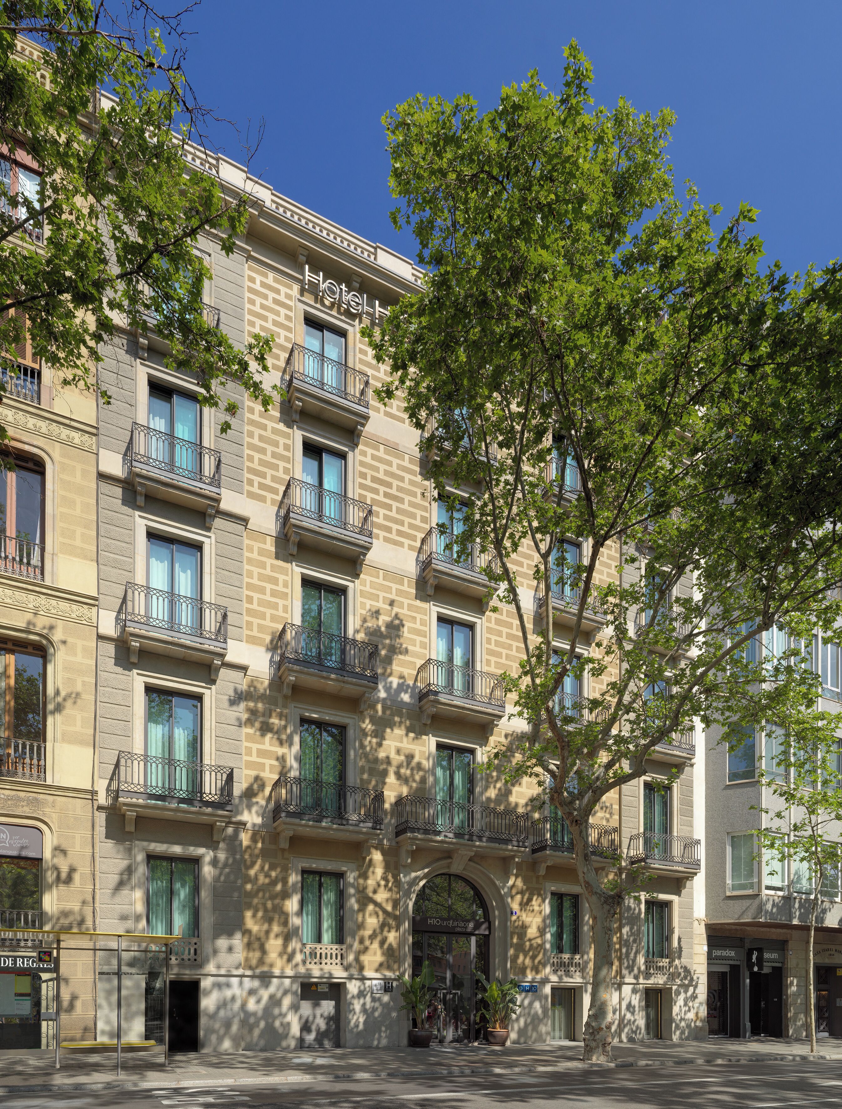 Un hotel de varios pisos con estilo arquitectónico clásico, que cuenta con balcones y una entrada central.