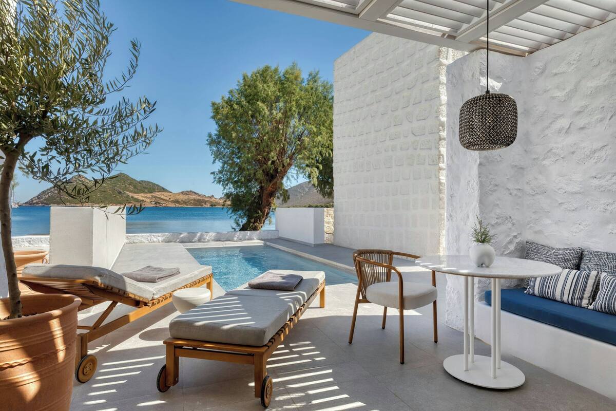 Ein moderner Außenbereich mit Pool, Liegestühlen und einem Tisch.