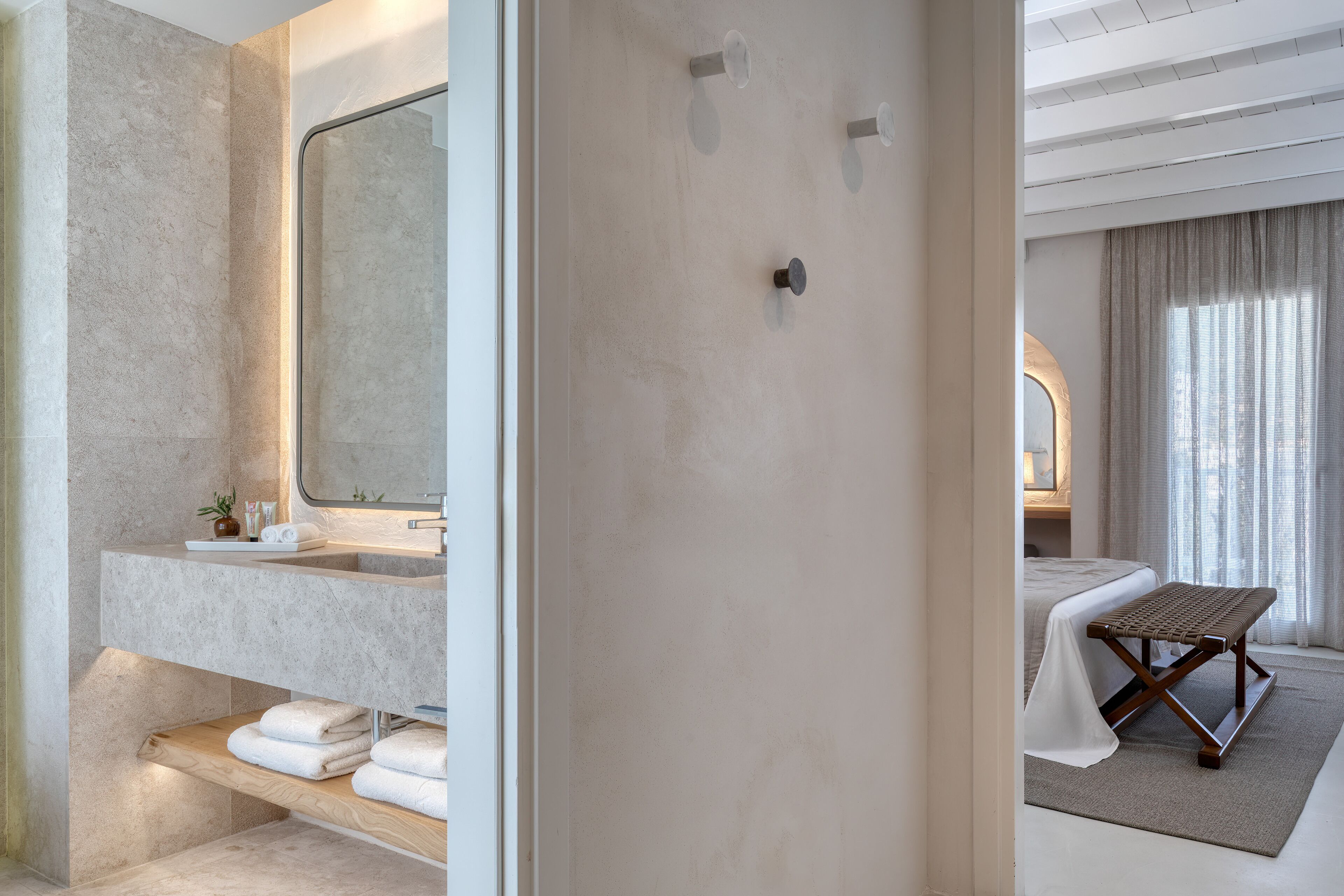 Un baño moderno con un espejo grande, una encimera con un lavabo y toallas ordenadamente dobladas.